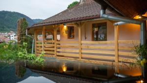 a house on the water next to a lake at Sun x Mountains - Old Town in Braşov