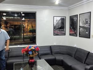 サンパウロにあるCenter Plaza Hotelのソファのある居間に立つ男