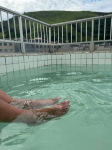 a person in the water in a swimming pool at Casa muito espaçosa com 3 quatos e churrasqueira in Juiz de Fora