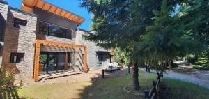 a house with a tree in front of it at Hygge Haus in Villa La Angostura