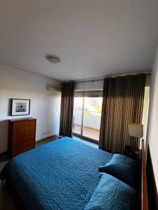 ein Schlafzimmer mit einem blauen Bett und einem Fenster in der Unterkunft Aparthotel Oceano Atlântico 1 in Portimão + 15 Fotos