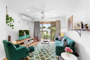 a living room with green chairs and a television at Seaside Serenity: Charming 2-Bedroom Getaway in Scarborough