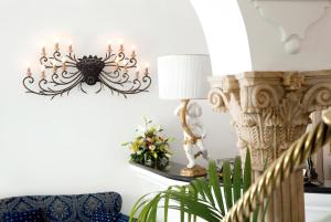 a living room with a chandelier and a chair at Hotel Reginella in Positano