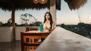 una mujer sentada en una mesa con una bebida en Hotel Sacbe Coba, en Cobá