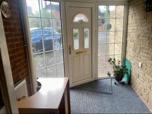 a hallway with a white door and a potted plant at Raj Rentals Ensuite House Share in Birmingham