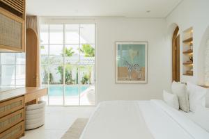 a bedroom with a bed and a view of a pool at Nisí Villas Bingin, Uluwatu in Uluwatu +150 photos
