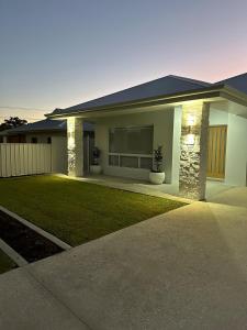 a house with two potted plants in the front yard at Straun Street House in Naracoorte