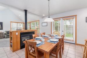 een eetkamer met een tafel en stoelen en een open haard bij Getaway in Pacific City