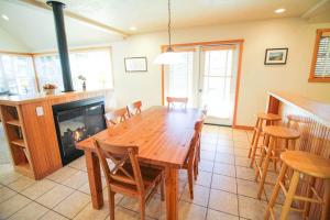 een eetkamer met een houten tafel en een open haard bij Getaway in Pacific City
