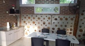 a dining room with a white table and chairs at Cabaña Las Catas in General Enrique Mosconi