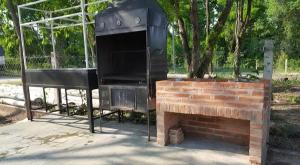 una parrilla y un banco en un parque en Cabaña Las Catas, en General Enrique Mosconi