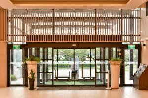 una hall aperta con porte in vetro e piante in vaso di Holiday Inn Taoyuan Airport by IHG a Dayuan