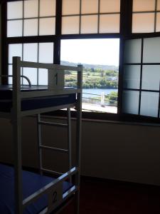 a bunk bed in a room with a large window at Albergue Folgueira in Portomarin