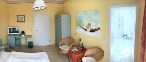 a living room with a table and a painting on the wall at Kastanienhof Hotel garni in Zinnowitz +34 photos