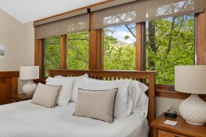 a bedroom with a bed with white pillows and a window at HOT TUB & PET-FRIENDLY Cabin in Cheshire Village in Black Mountain