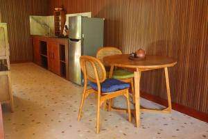 a kitchen with a table and chairs and a refrigerator at Umah D Meranggi in Banjarangkan