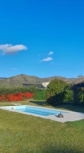 a swimming pool in the middle of a field with flowers at La Macarena Suites in Villa General Belgrano +27 photos