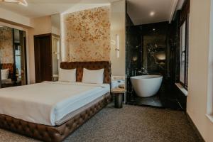 sypialnia z dużym łóżkiem i wanną w obiekcie Highgarden Hotel w mieście Tbilisi City