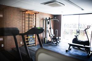 a gym with two tread machines and a brick wall at Apartamento Loft Lazer Completo in Belo Horizonte