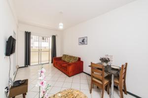 ein Wohnzimmer mit einem roten Sofa und einem Tisch in der Unterkunft Acomodações Campinas By Rental in São José