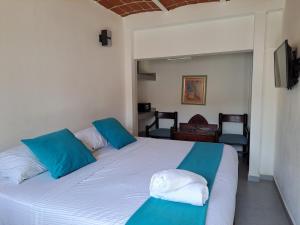 a bedroom with two beds with blue and white pillows at Hotel Diamante Sayulita in Sayulita