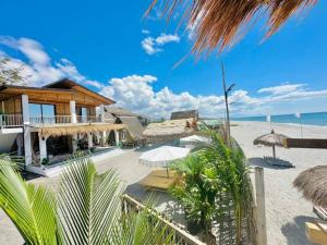 a resort with a beach with umbrellas and the ocean at Euphoria Zambales in Botolan