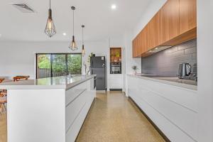 una cucina con ripiani bianchi e frigorifero di Villa Simone - Tranquil Hideaway in the Heart of Echuca a Echuca