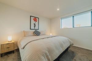 a bedroom with a large bed and a window at 2BR Stay in the City Free Wi-Fi - Gloucester in Christchurch