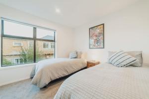 a bedroom with two beds and a large window at 2BR Stay in the City Free Wi-Fi - Gloucester in Christchurch