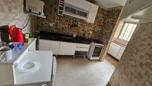 a small kitchen with white cabinets and a stove at - Apê perto do Alphaville - in Osasco