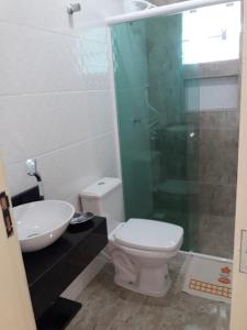a bathroom with a toilet and a glass shower at Apartamento na Praia de Pontal do Sul- Pontal do Paraná in Pontal do Paraná