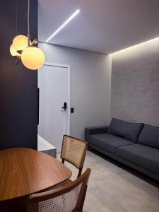 a living room with a table and a couch at Apartamento Loft Lazer Completo in Belo Horizonte