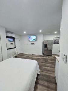 a bedroom with a bed and a tv on the wall at Beautiful studio with private backyard in Abbeyville