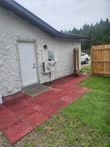 a stone house with a white door and a yard at Beautiful studio with private backyard in Abbeyville