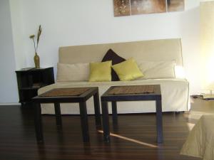 a couch with two tables in a living room at Nikol Apartments in Berlin