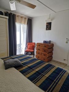 a bedroom with a bed and a dresser and a chair at Beautiful F2 in a blue beach residence in Oyster Pond