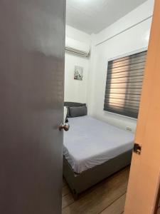 a small bedroom with a bed and a window at San Jose del monte Bulacan gumaok with aircon unit 1 in Mangangpico