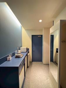 Saijō-chōにあるHotel JOYCEの青いカウンターと青いドアのあるバスルーム