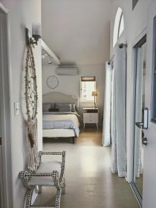 Un dormitorio blanco con una cama y una silla. en Venice Canals & Beach Guest House, en Los Ángeles