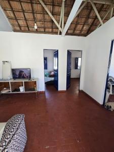 a living room with a bed and a wooden floor at Casa de praia em Guaxindiba in Salinas