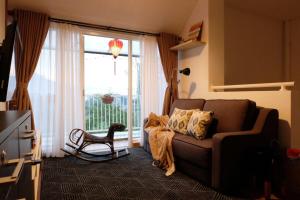 a living room with a couch and a large window at Kananta Home in Bongkar 2