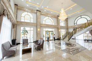 a lobby with a staircase and chairs and a chandelier at Duc Huy Grand Hotel and Spa in Lao Cai