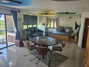 ein Wohnzimmer mit einem Tisch und einem Sofa in der Unterkunft Villa Germania in Jomtien Beach