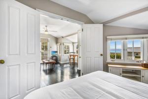 ein weißes Schlafzimmer mit einem Bett und einem Schreibtisch in der Unterkunft Cottage 1 Hyams Beach Seaside Cottages in Hyams Beach