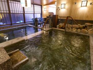 a large pool of water in a room with wooden walls at Dormy Inn Sapporo Annex in Sapporo +83 photos