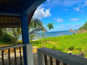 a view of the ocean from the porch of a house at L'Astrolabe - Riverside Bungalow with Sea View in Baras