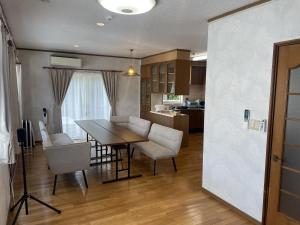 a kitchen and dining room with a table and chairs at ritomaru house iki ashibe in Iki