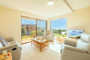 ネルソン・ベイにあるPromenade 9, 8 Intrepid Cl - spectacular water views, air conditioningのソファとテーブルのあるリビングルーム