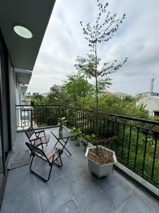 eine Terrasse mit 2 Stühlen und einem Baum auf dem Balkon in der Unterkunft BB Homestay in Thôn Trường Giang