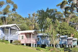a row of houses with pink and blue balconies at Cottage 2 Hyams Beach Seaside Cottages in Hyams Beach